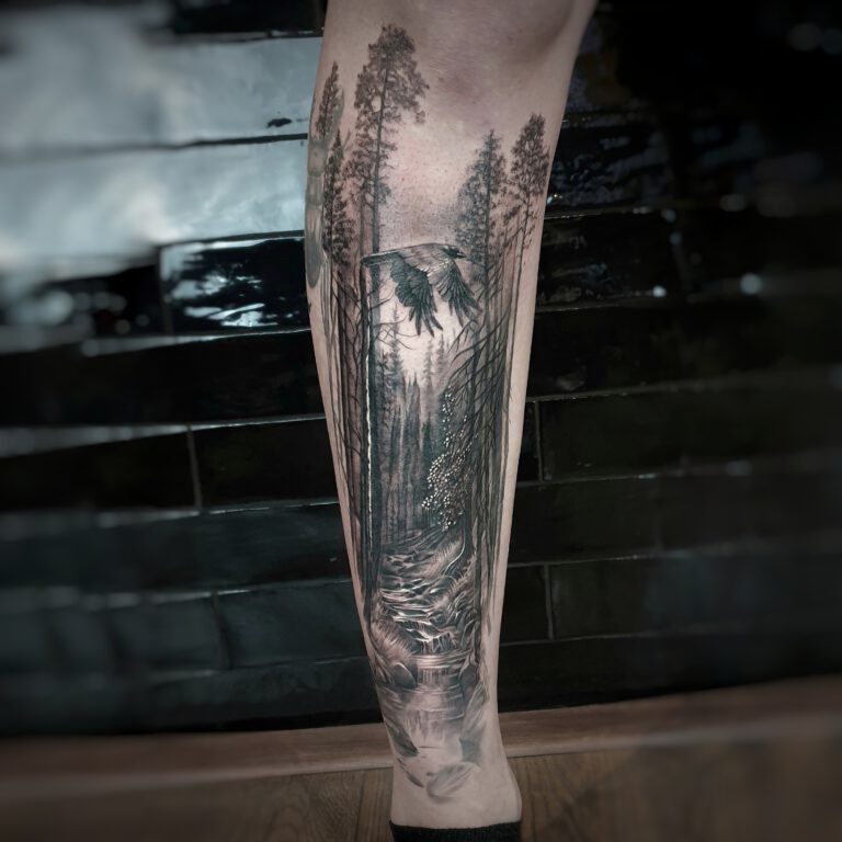 black and grey realistic forest landscape tattoo by marloes lupker