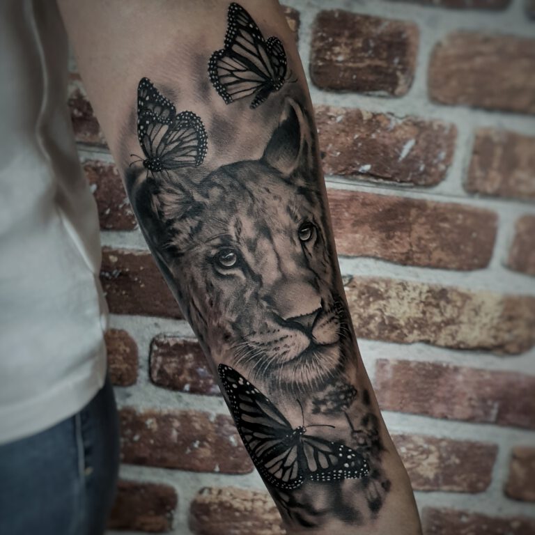 black and grey lioness and butterfly tattoo by marloes lupker