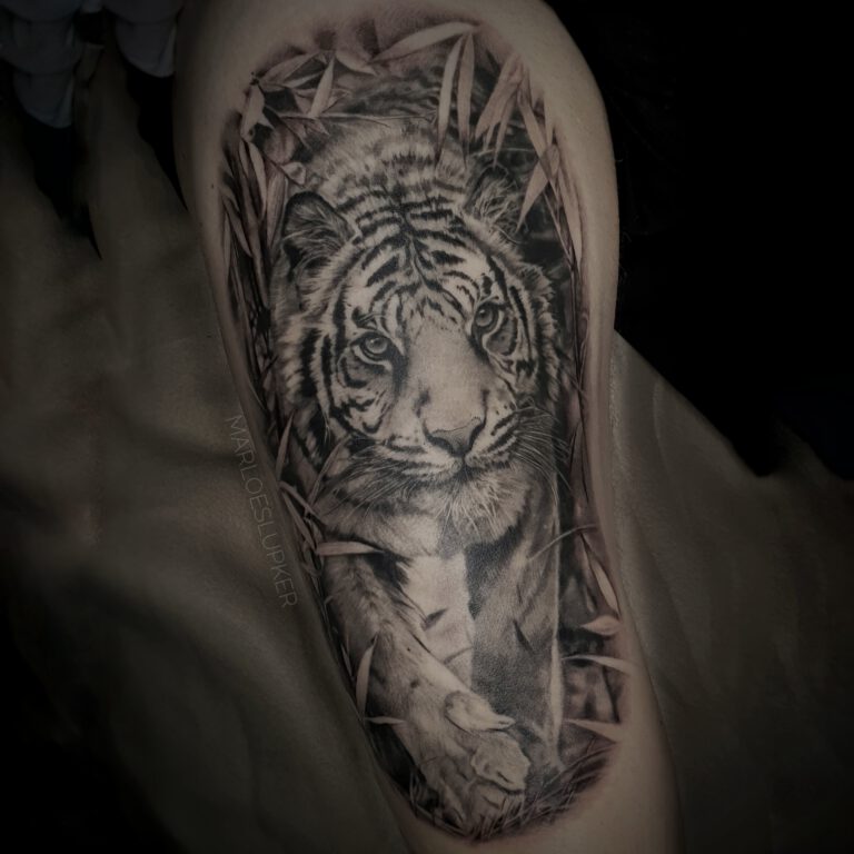 black and grey realistic tiger in the jungle tattoo by marloes lupker